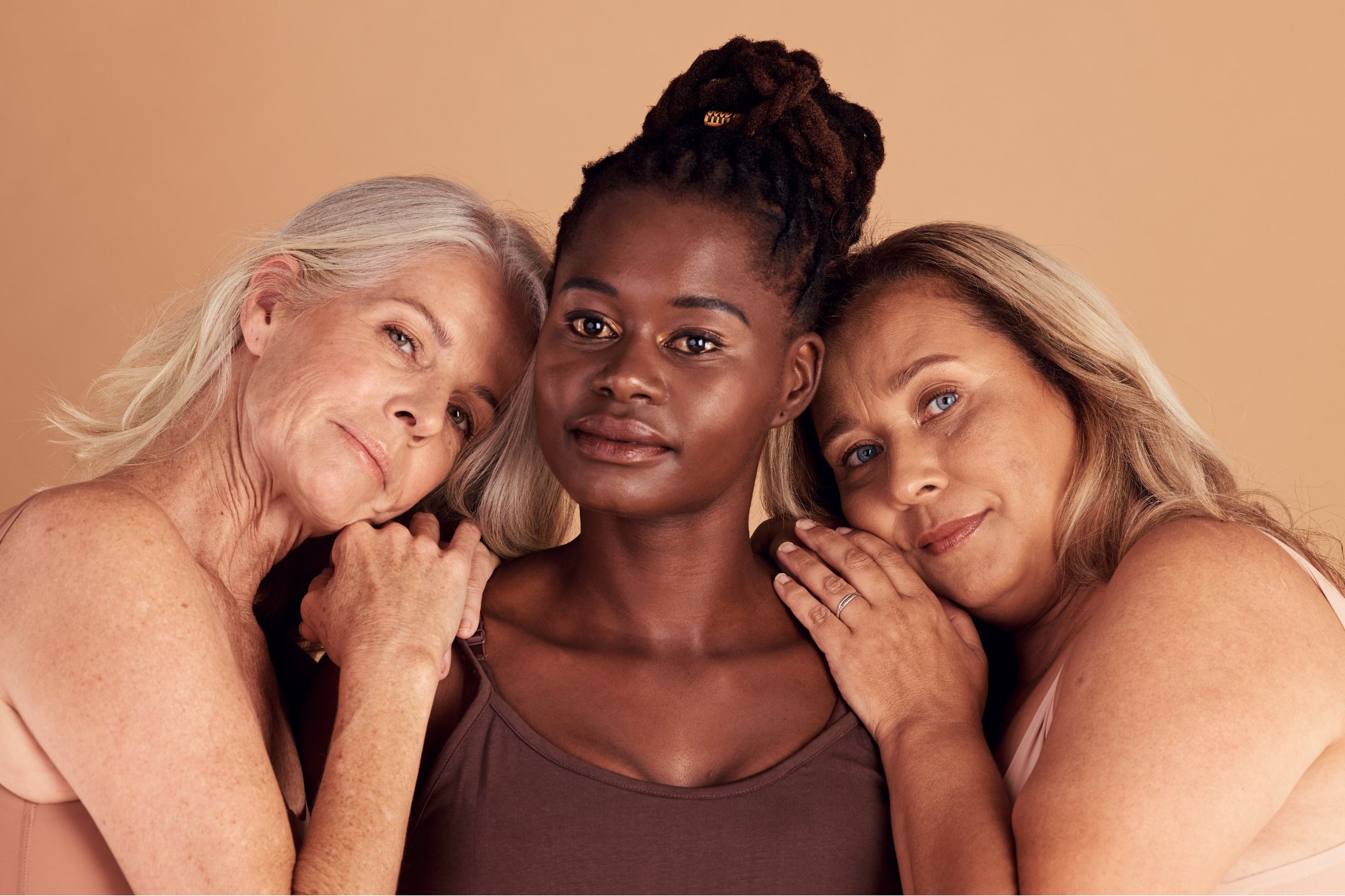 Three women of different ages pose together.